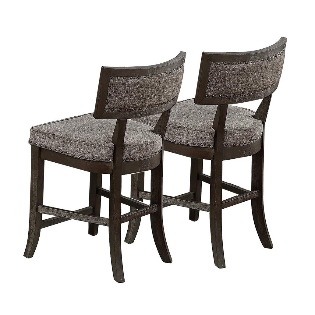Two distressed dark wood counter stools with grey upholstered seats and studded backs