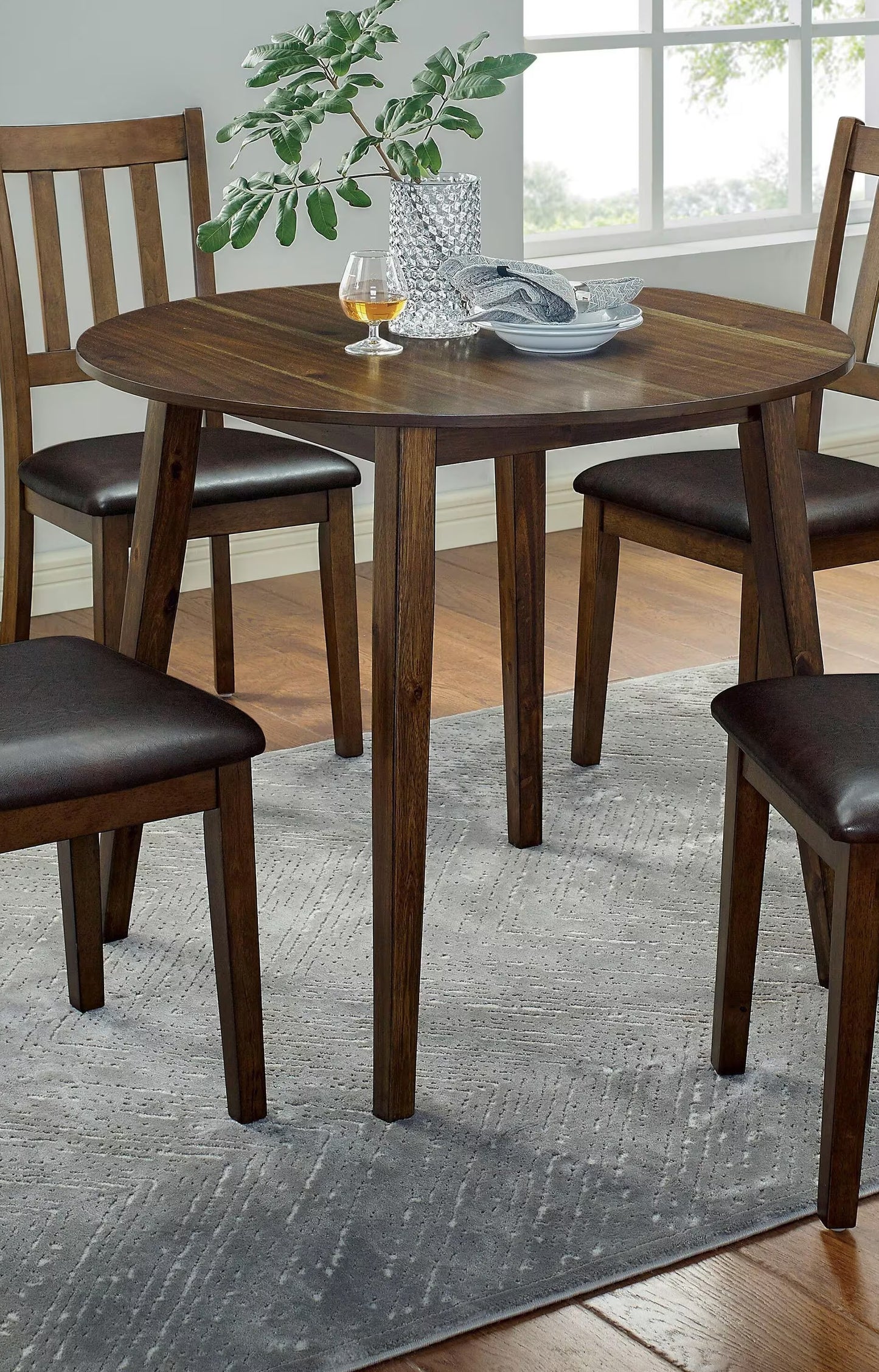 Dark wood round dining table with four matching chairs
