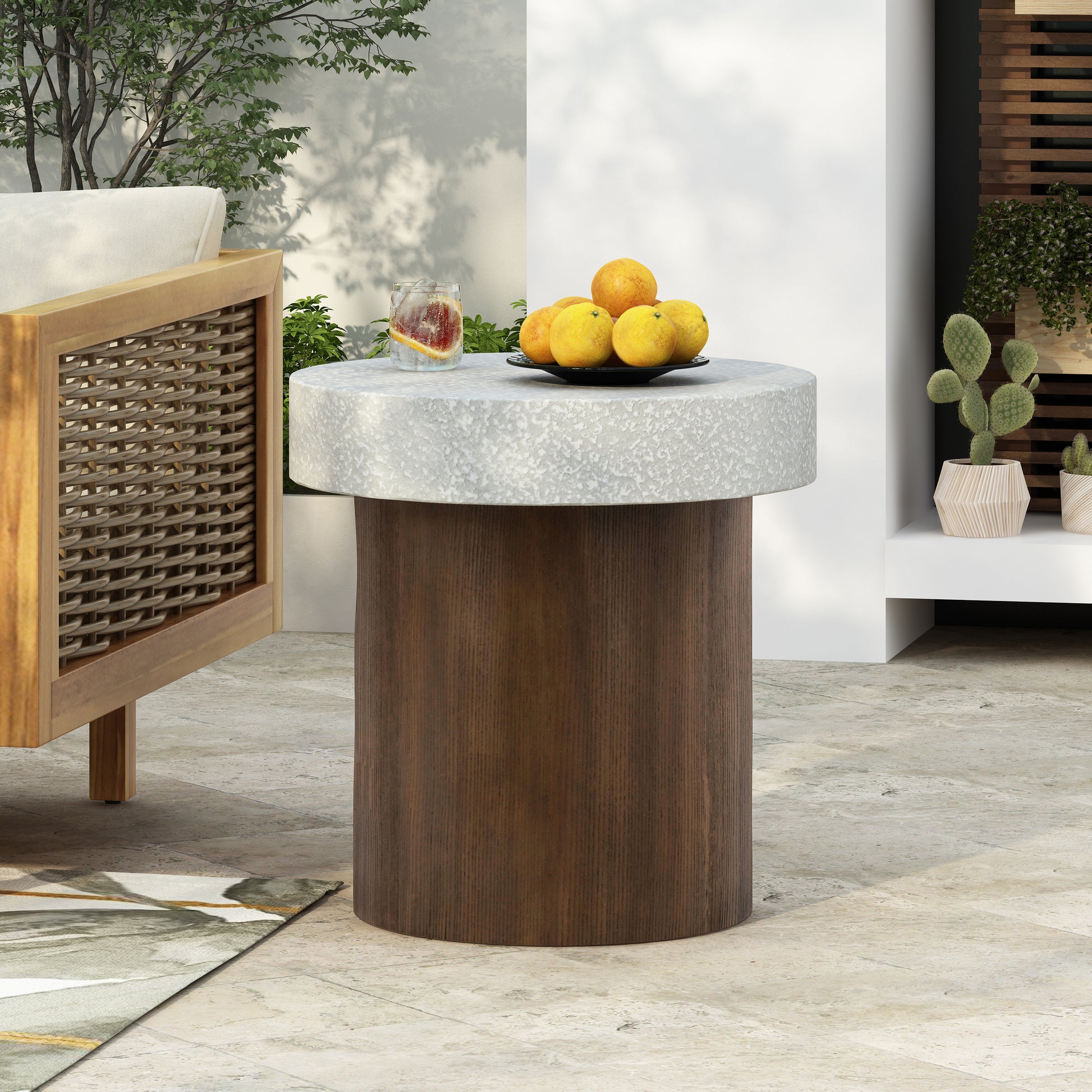 Round concrete and wood side table with fruit bowl and drink