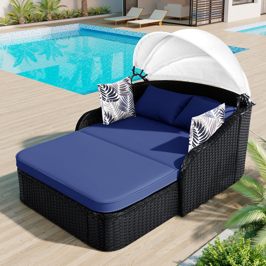 Black wicker outdoor daybed with blue cushions and white canopy