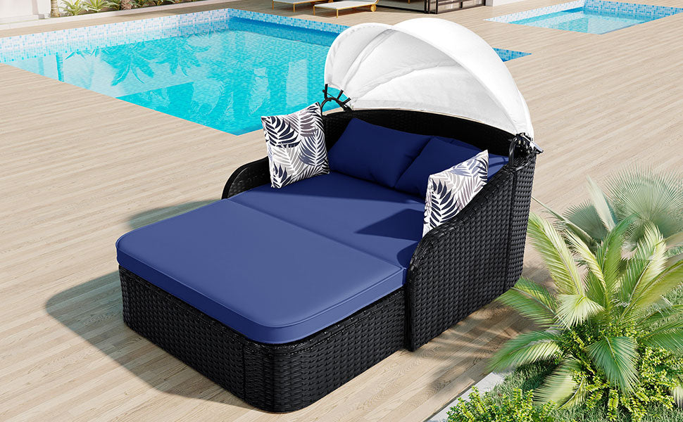 Black wicker chaise lounge with navy cushions and canopy