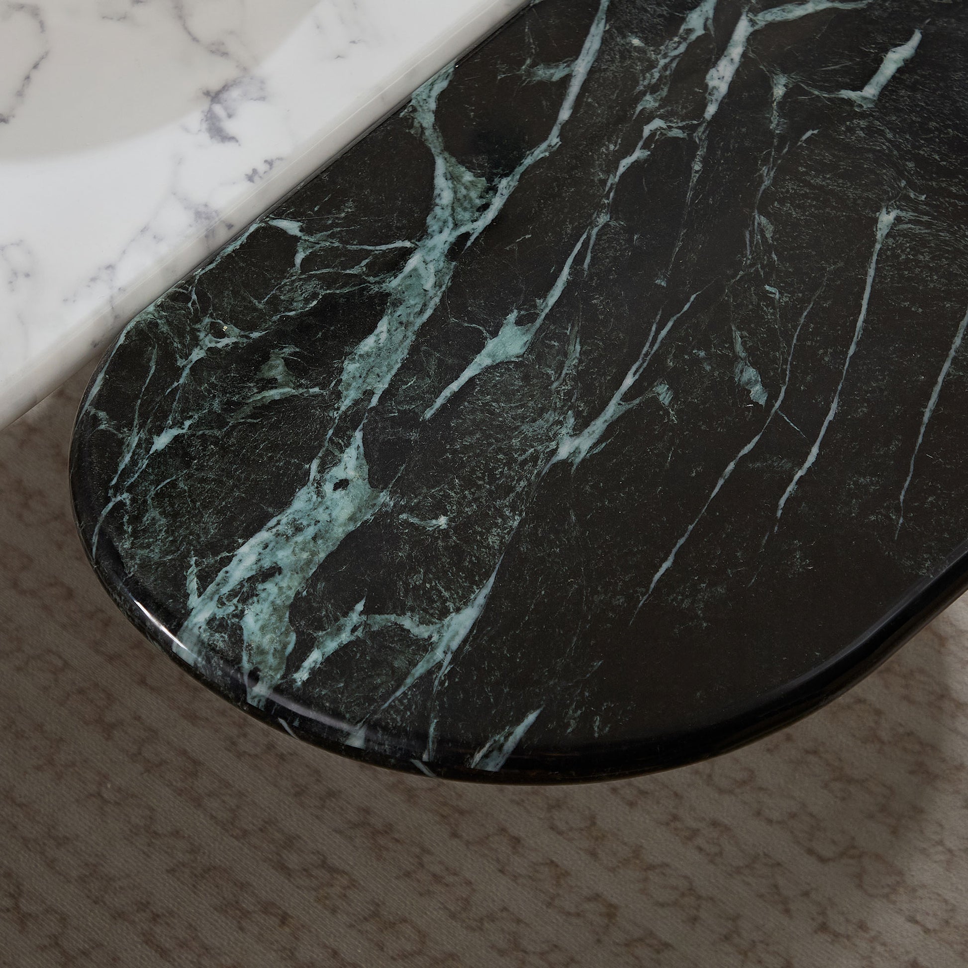 Dark green marble tabletop with white veining showcasing its luxurious texture