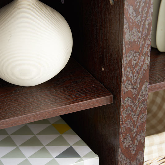 White textured ceramic vase with horizontal grooving on a dark wood shelf