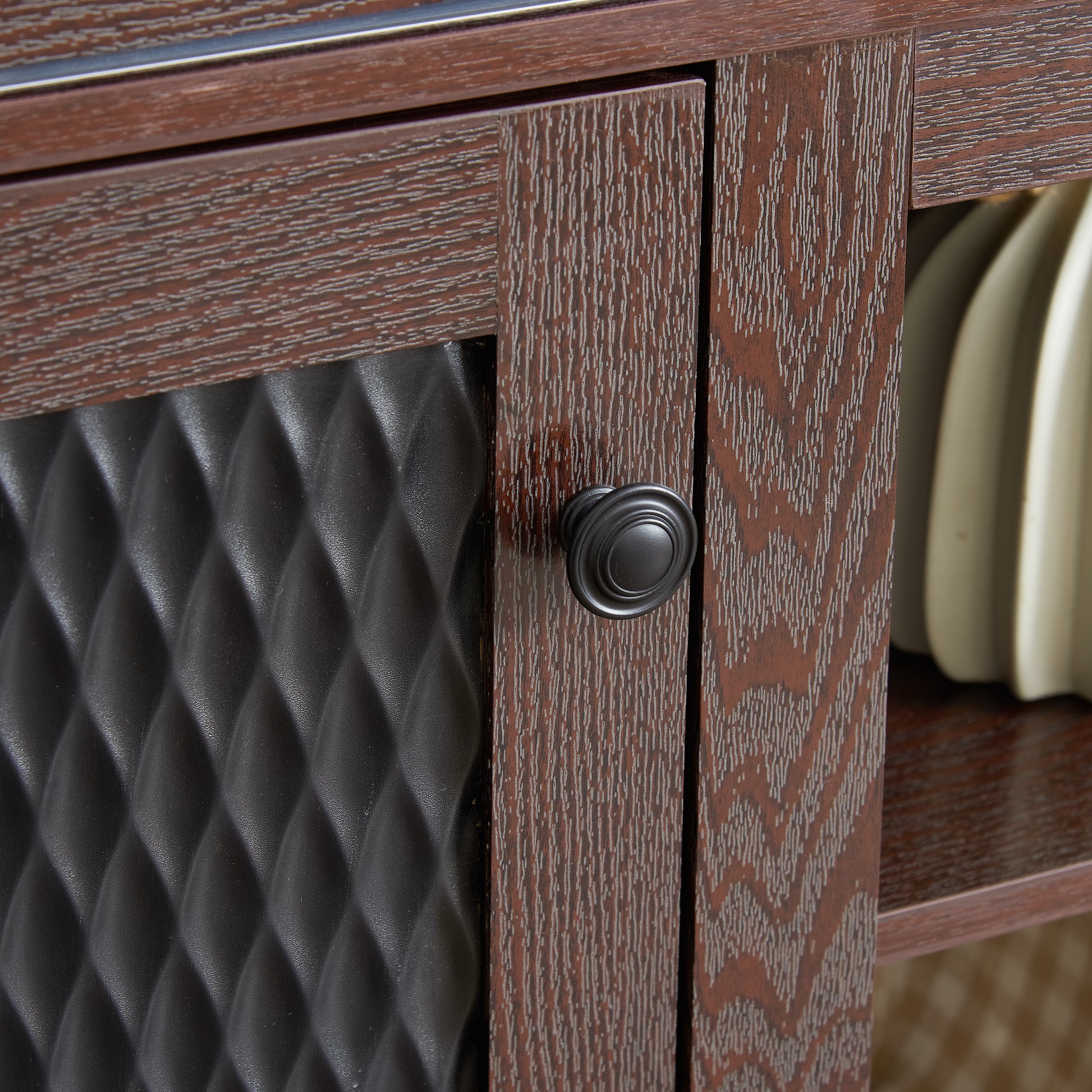 Dark wood cabinet door with black textured panel and round handle