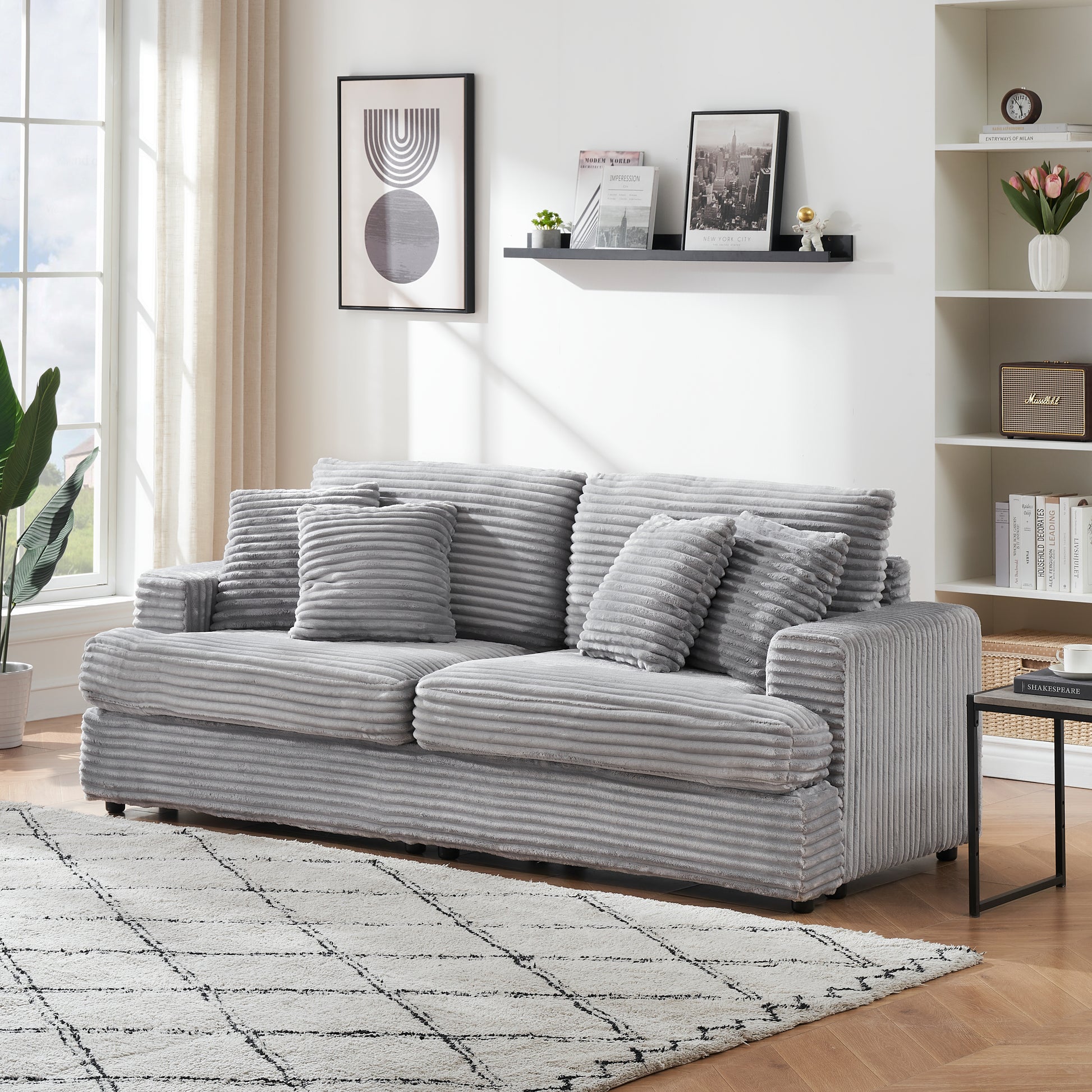 Plush grey corduroy sofa with three accent pillows for comfortable living room seating