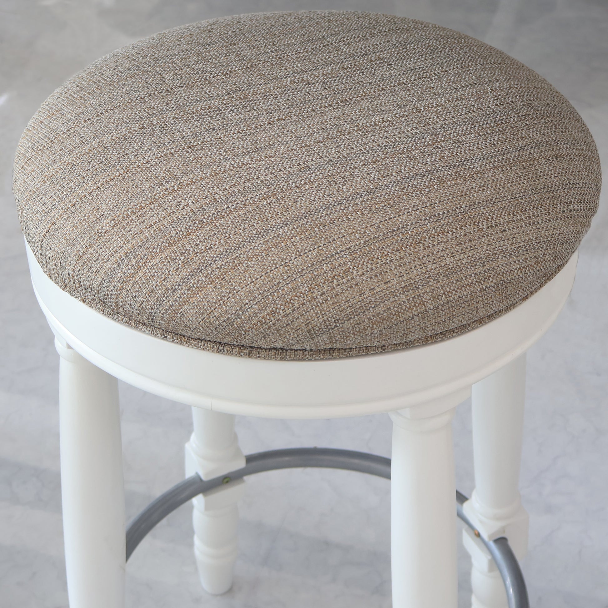 Cream textured fabric upholstered stool with white carved legs