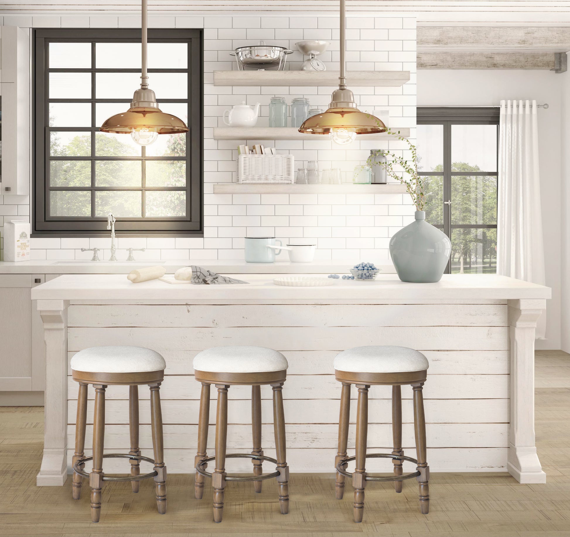 Three white upholstered bar stools with wooden legs arranged around a kitchen island