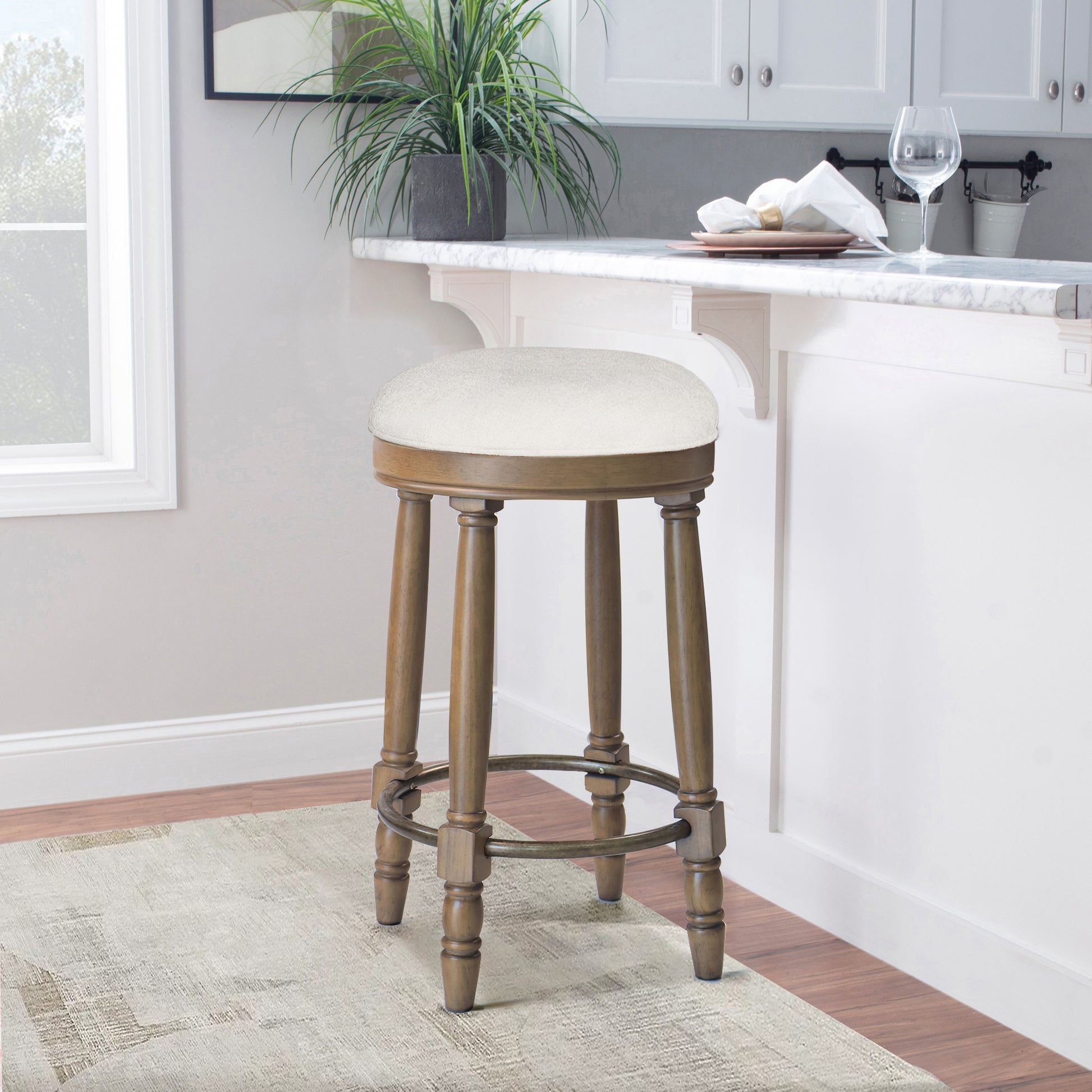 Cream upholstered swivel bar stool with turned wood legs and metal footrest