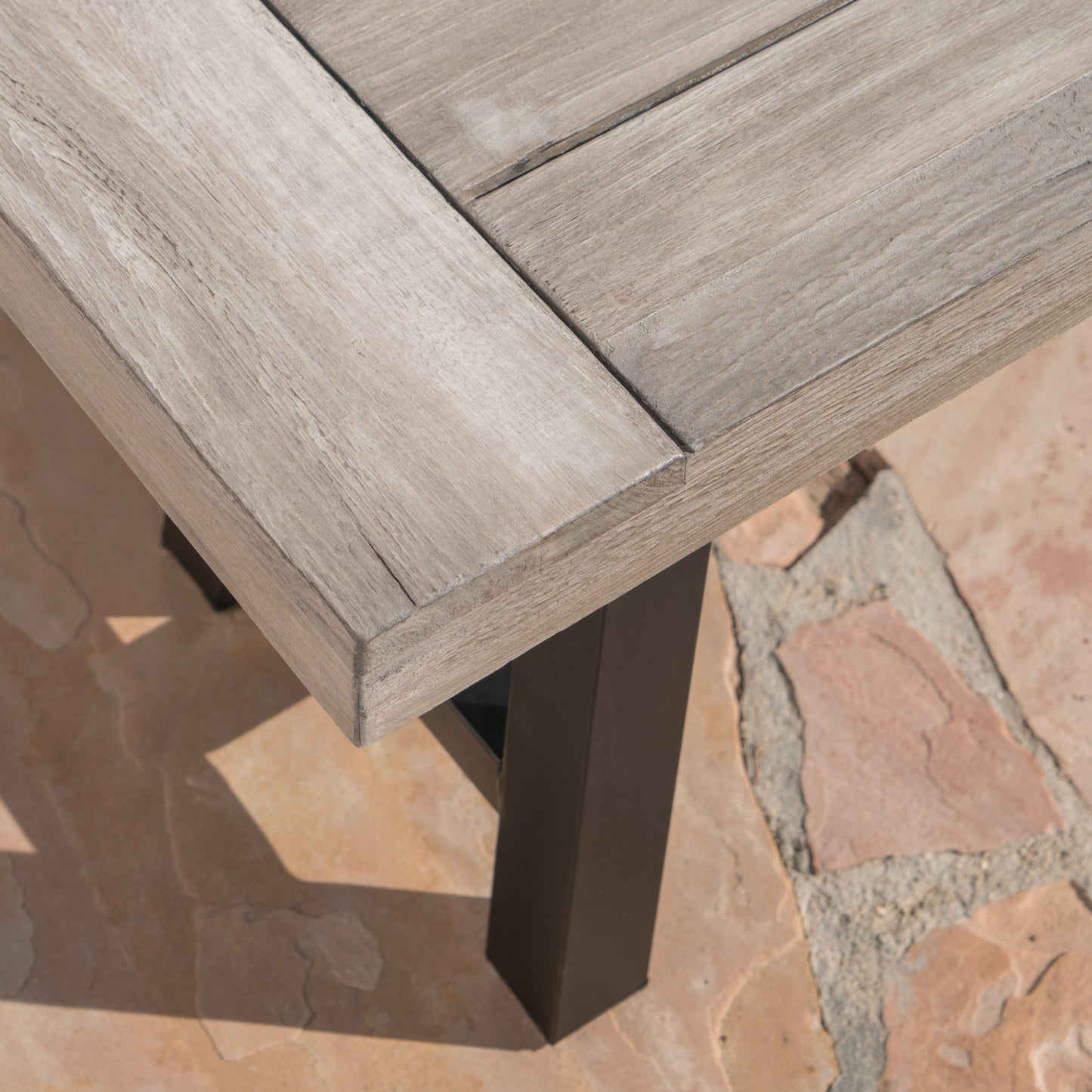 Grey washed wood patio table top with dark metal legs
