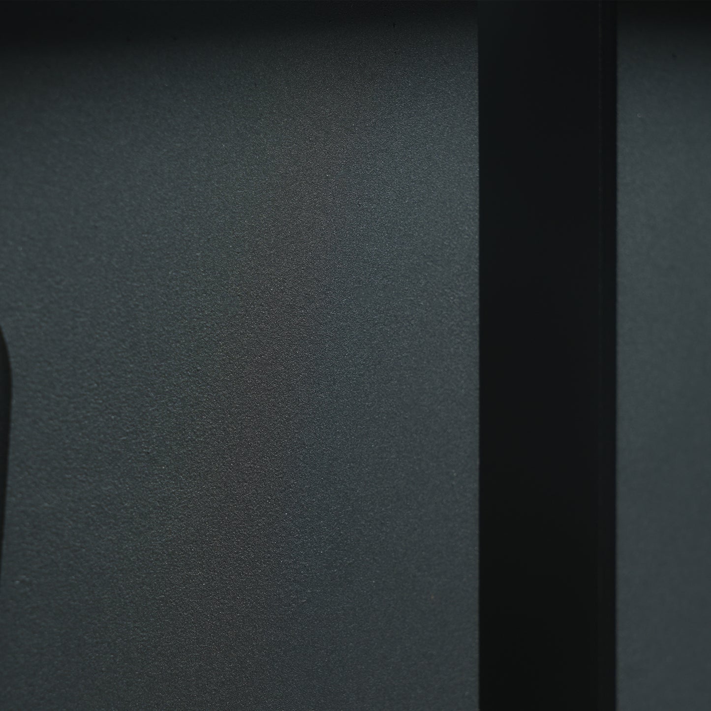 Dark grey textured metal panel with vertical black accent strip