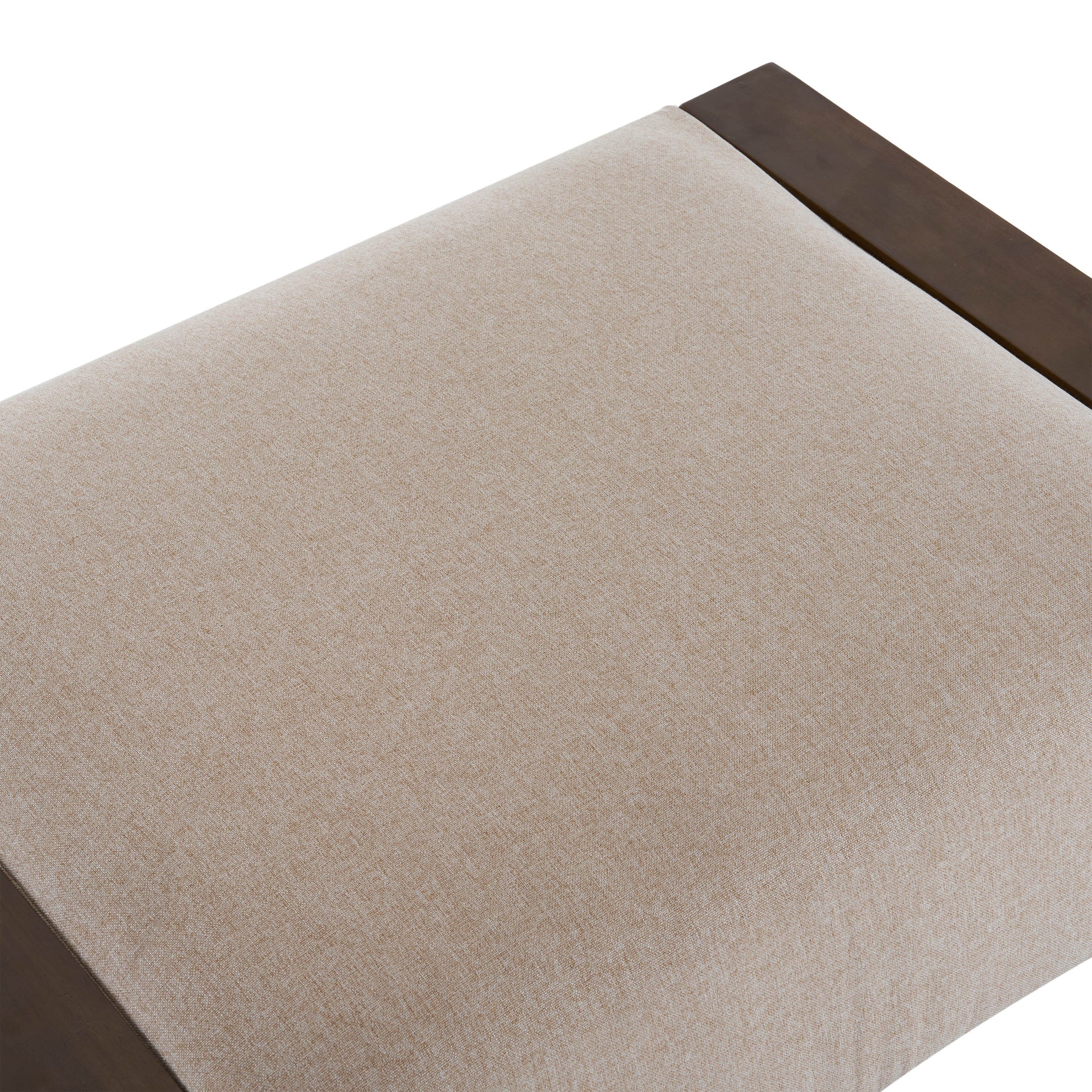 Closeup of a beige linen upholstered bench seat with dark wood trim