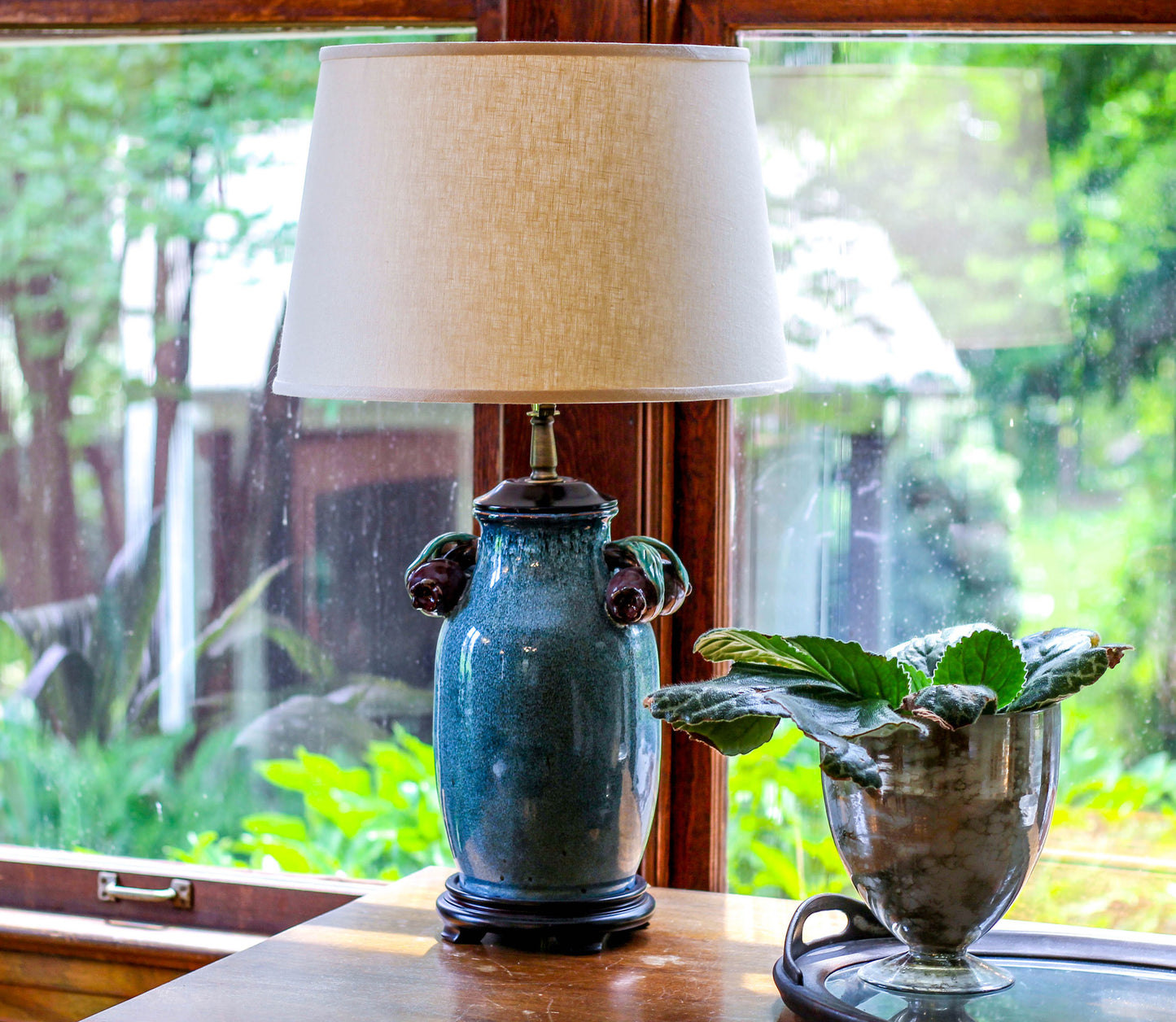 Teal ceramic table lamp with floral accents and linen shade
