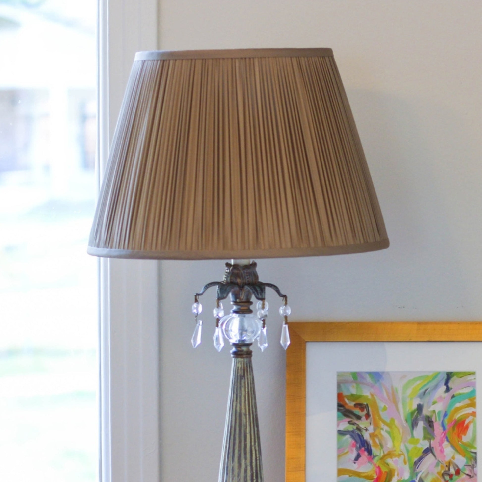 Antique brass table lamp with pleated tan shade and crystal accents