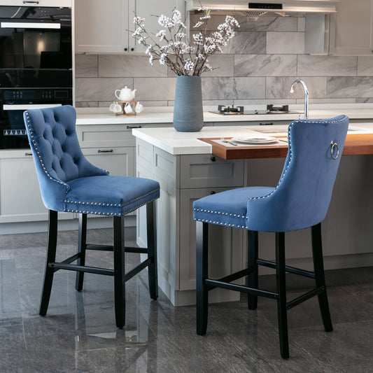 Tufted blue velvet bar stool with silver nailhead trim and a back ring detail
