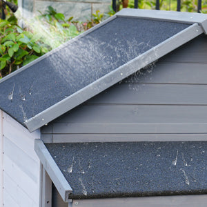 Waterproof asphalt roof on a gray wooden dog kennel