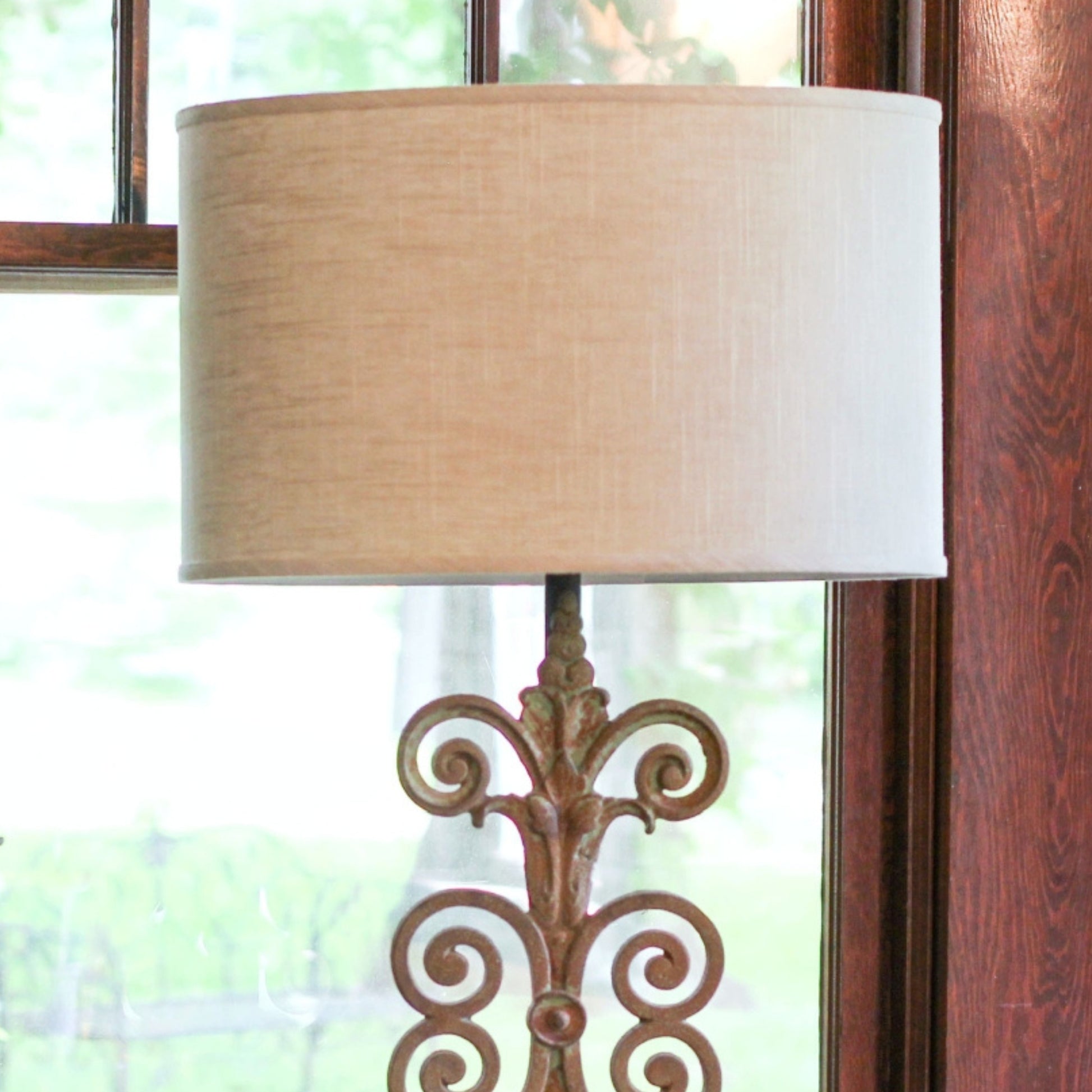 Bronze ornate table lamp base with a linen drum shade