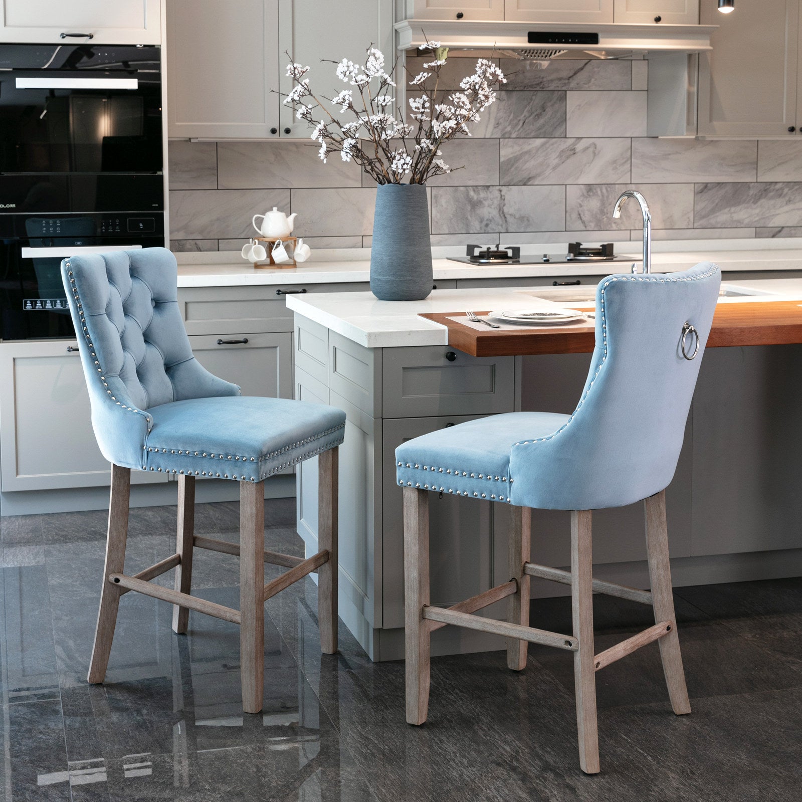 Light blue velvet tufted bar stool with silver nailhead trim and ring detail