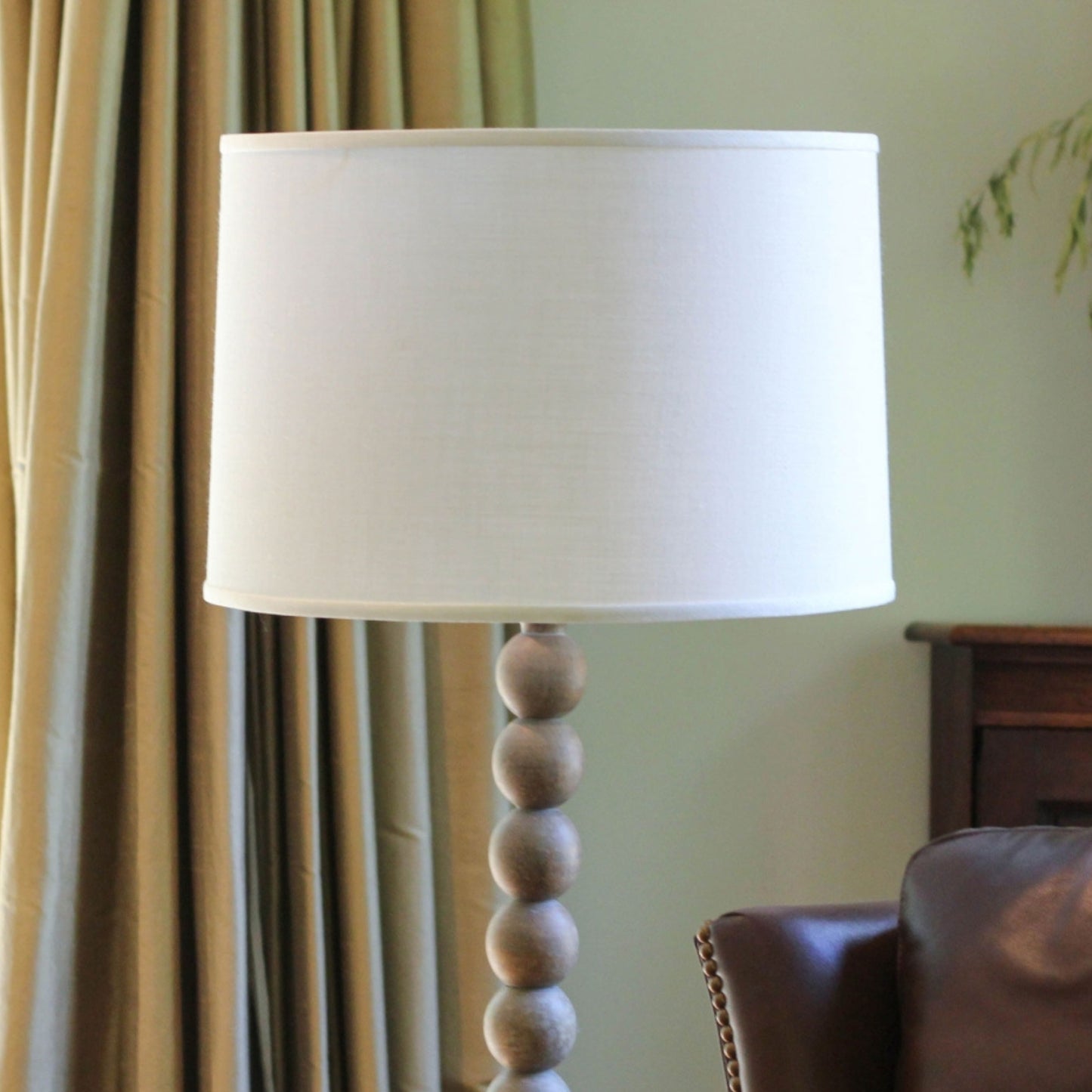 Neutral toned floor lamp with stacked wooden spheres and white drum shade