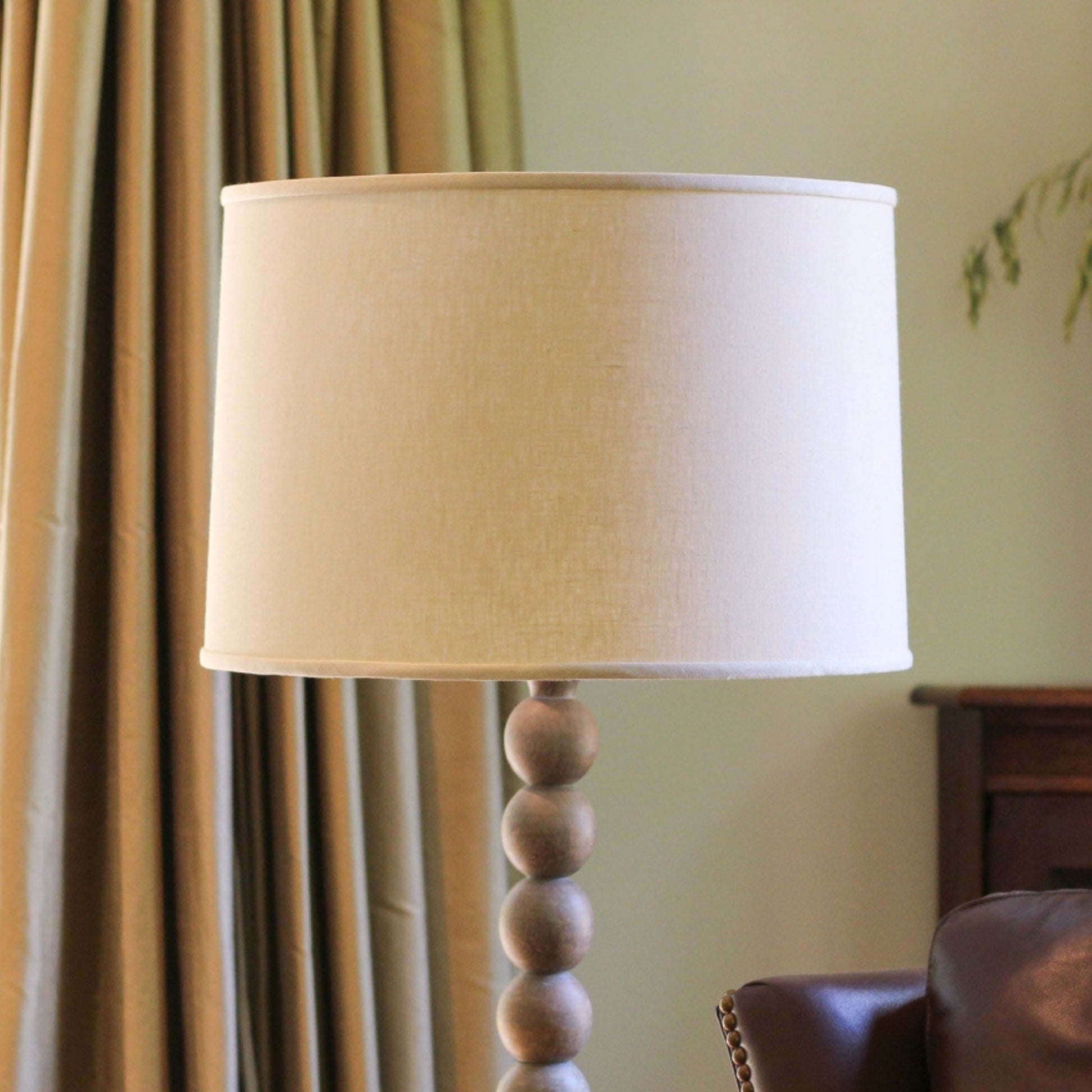 Cream drum lampshade on a lamp with stacked wooden sphere base