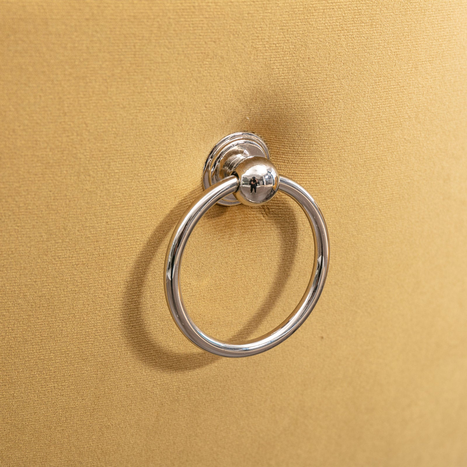 Gold velvet ottoman detail with a silver ring pull
