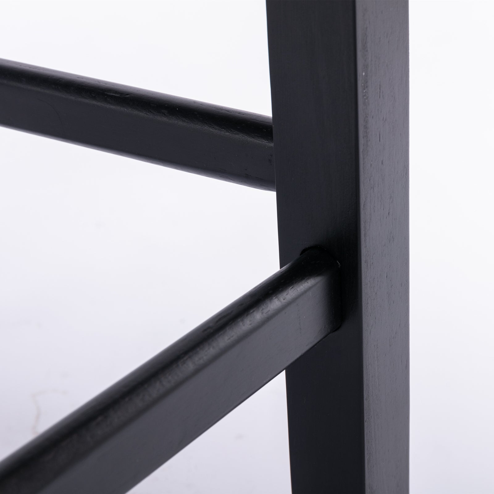 Black wooden bar stool leg detail showing joinery