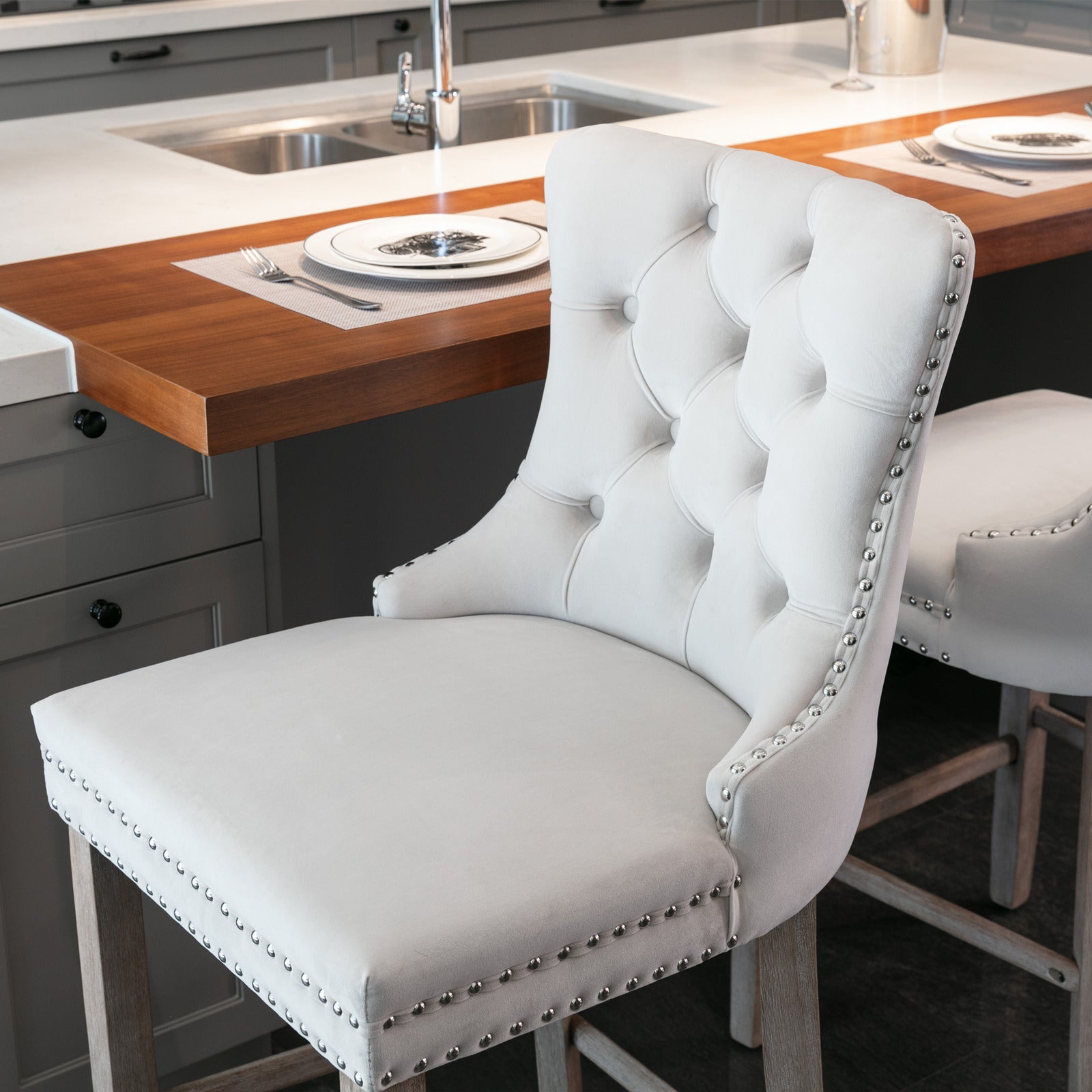 Cream velvet tufted bar stool with silver nailhead trim and wooden legs