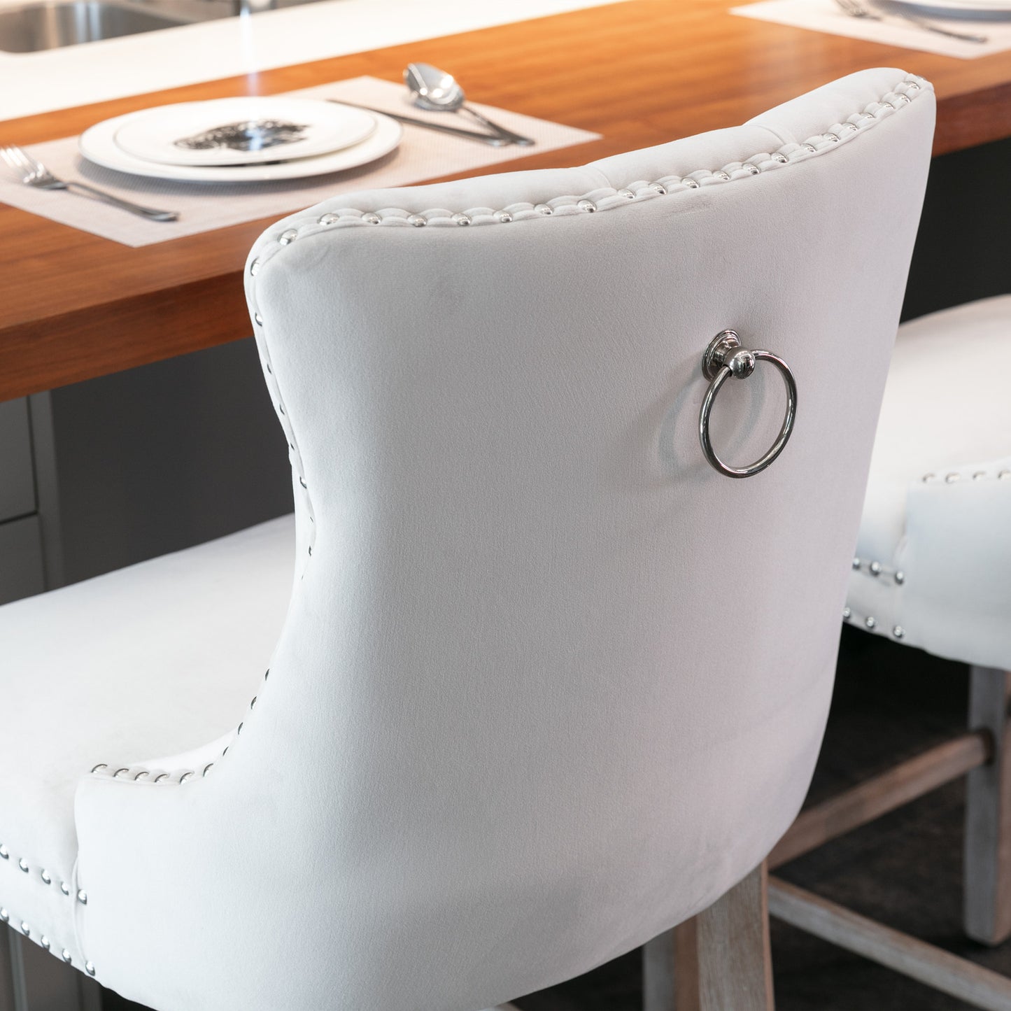 White tufted velvet bar stool with silver ring pull and decorative nailhead trim