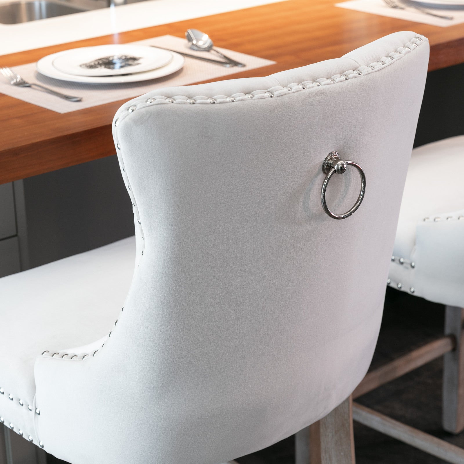 White tufted velvet bar stool with silver ring pull and decorative nailhead trim