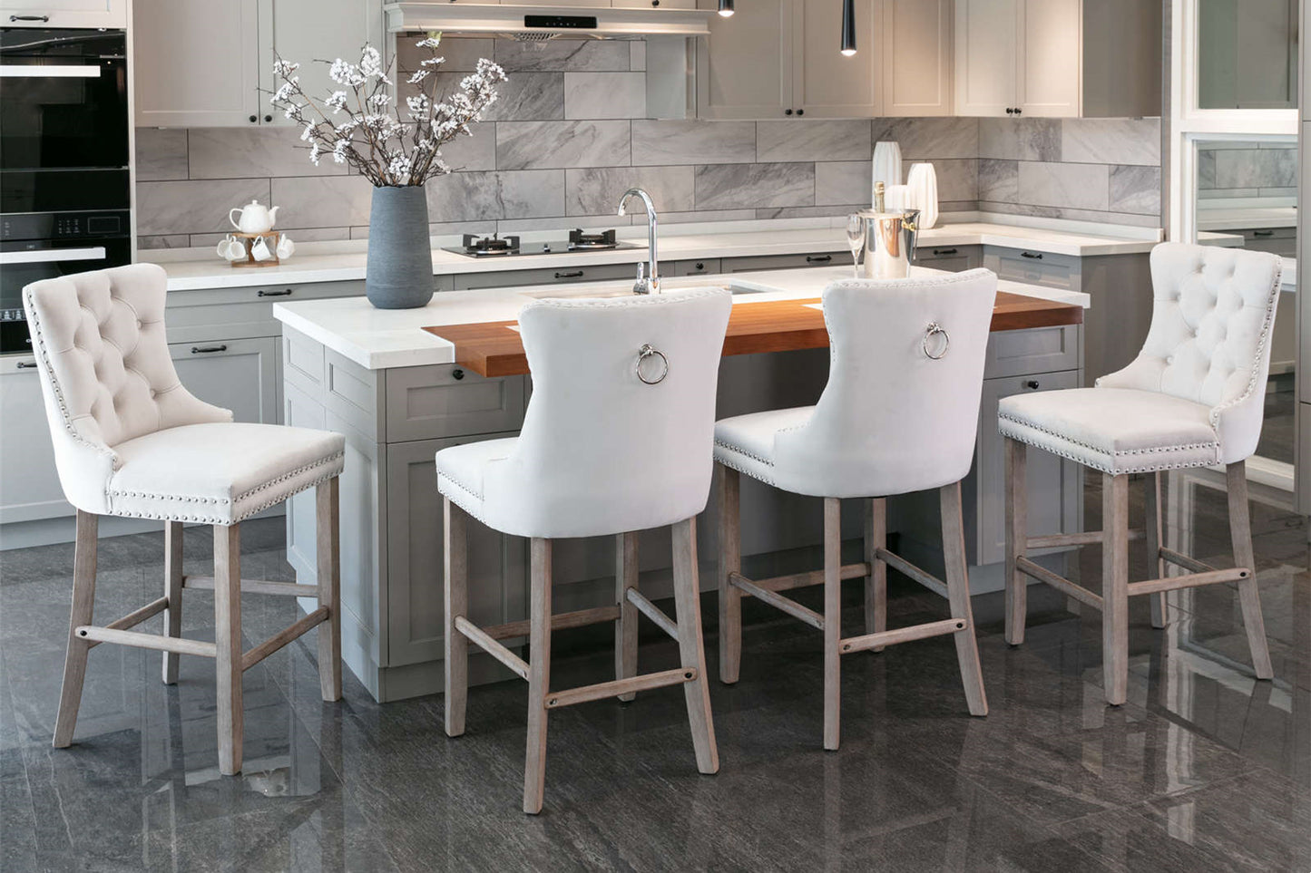 Elegant white tufted bar stools with silver nailhead trim around a kitchen island