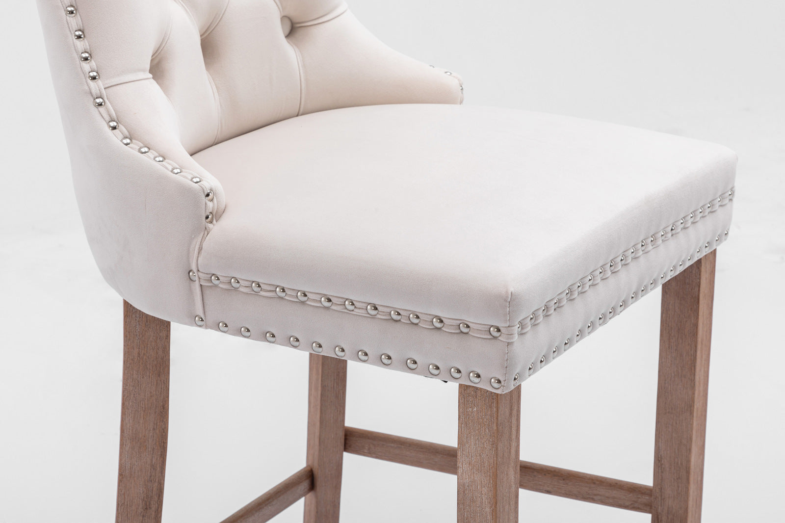 Cream tufted bar stool with silver nailhead trim and light wood legs
