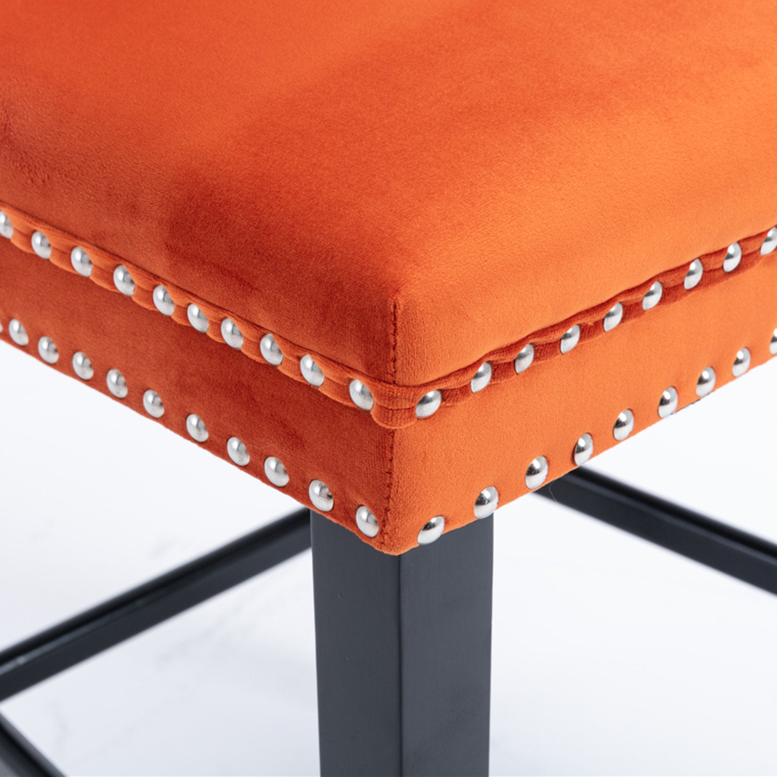 Orange velvet bar stool with silver nailhead trim and black metal legs