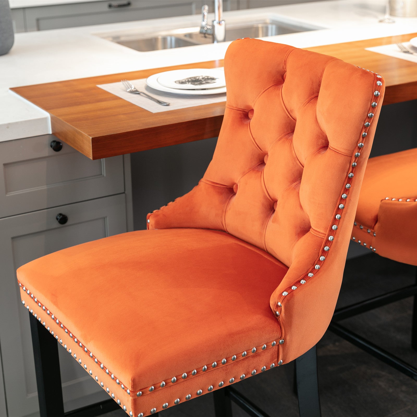 Orange velvet tufted bar stool with silver nailhead trim