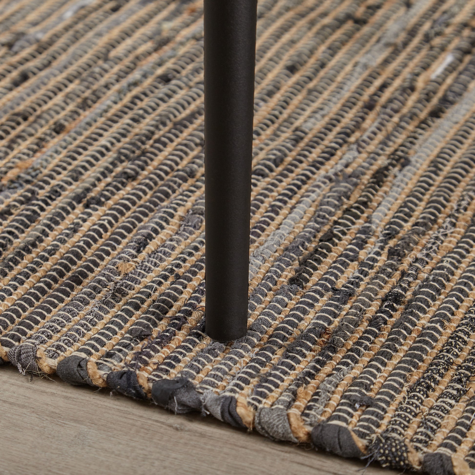Woven natural fiber rug with gray and tan braided stripes