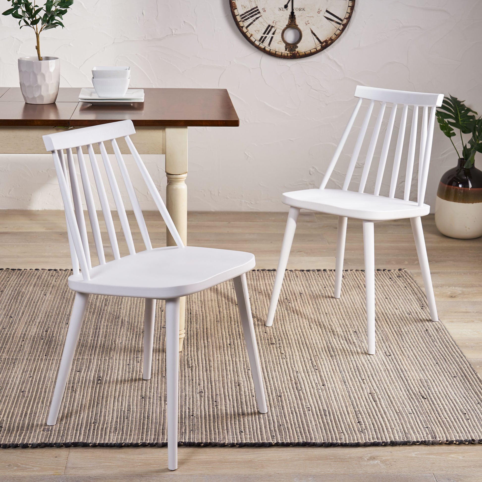 White spindle back dining chairs with light wooden legs