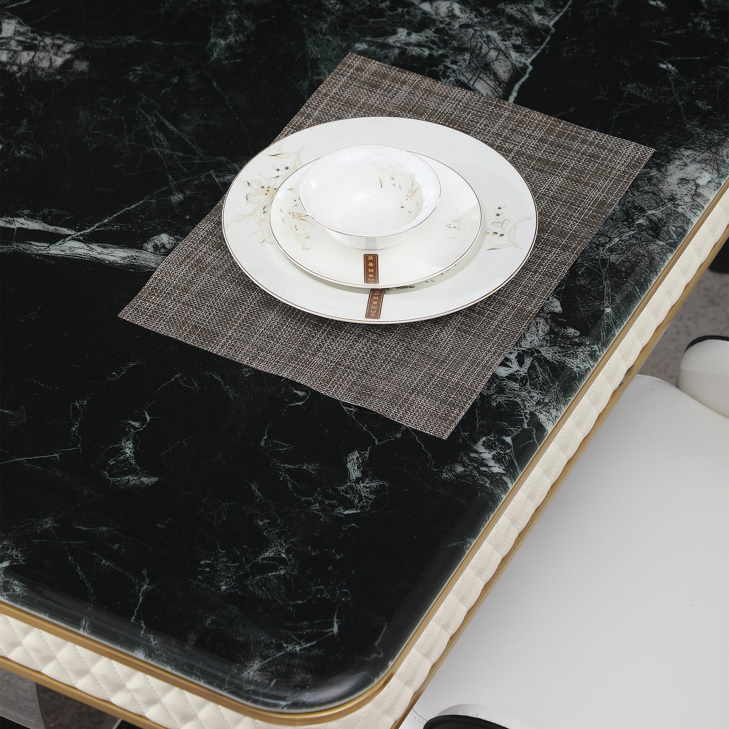 Elegant white porcelain dinner plate set with subtle floral design on dark marble tabletop