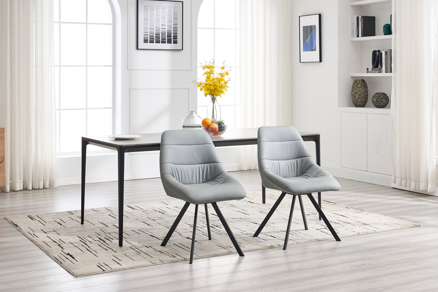Two modern grey leather dining chairs with swivel bases