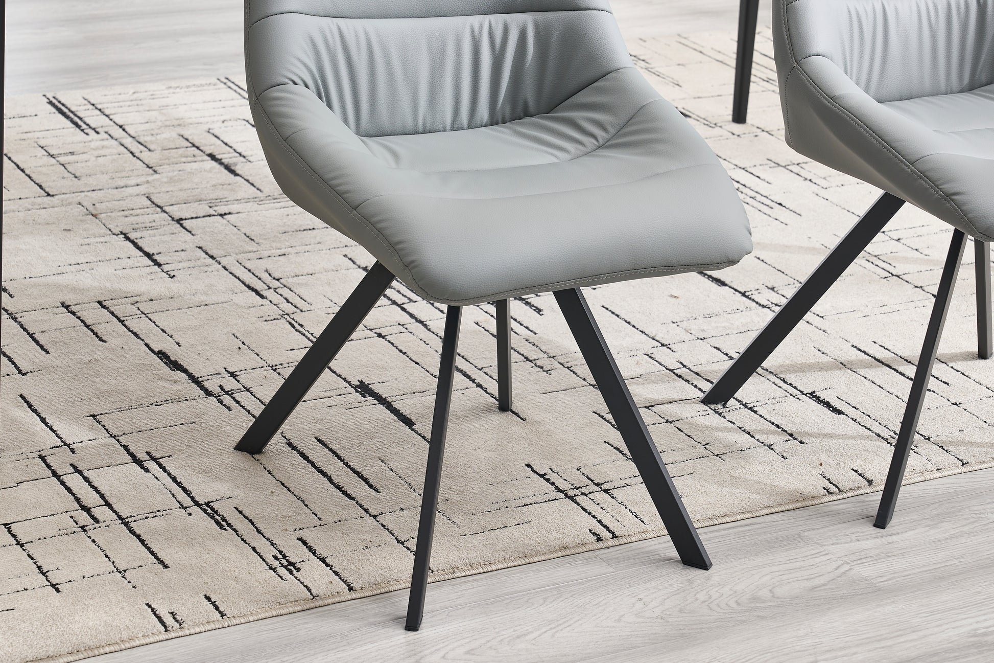 Contemporary grey faux leather dining chair with sleek black metal legs