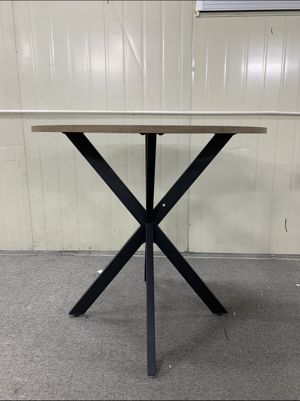 Round oak dining table with black metal spider base