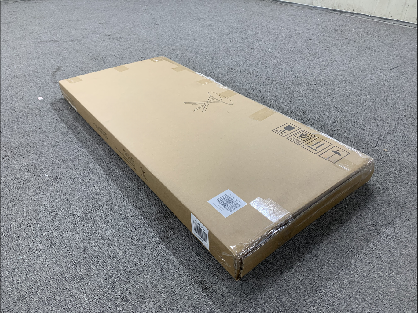 Flatpack cardboard box containing a black folding chair with shipping labels