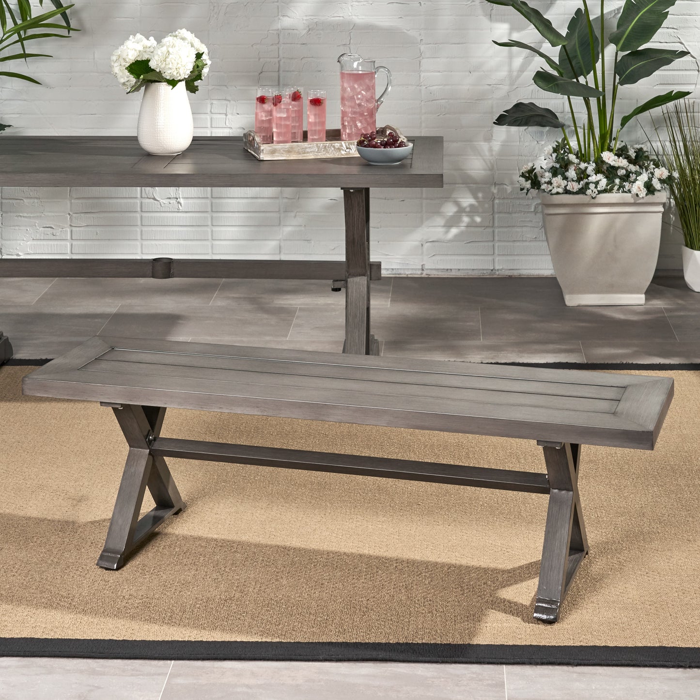 Gray wooden outdoor bench with slatted seat and Xshaped legs