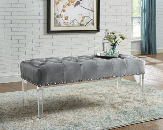 Grey tufted velvet bench with silver nailhead trim and clear acrylic legs