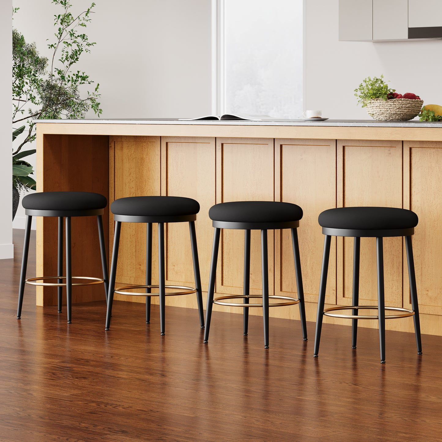 Four black upholstered bar stools with gold footrests arranged by a wooden kitchen island