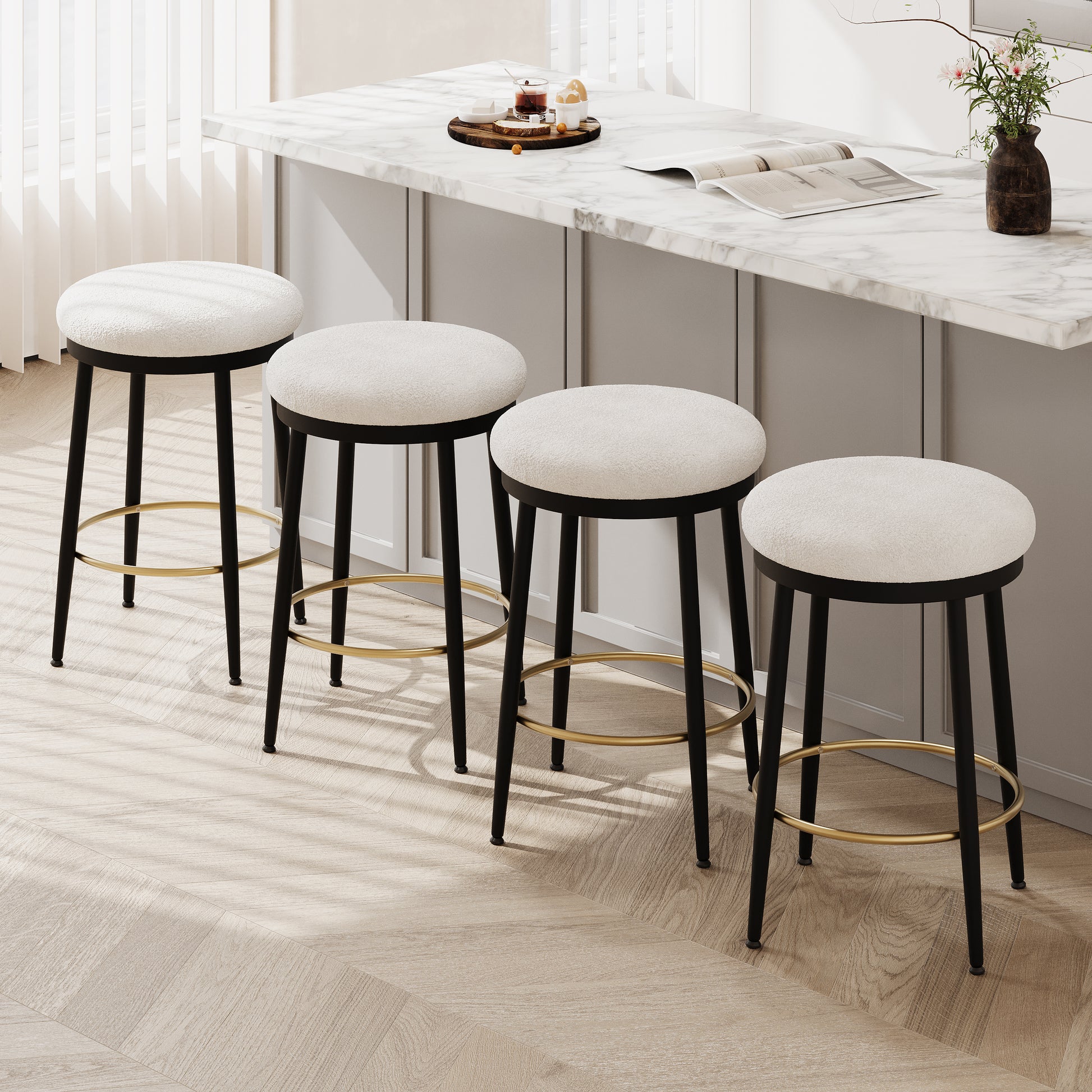 Four white textured fabric bar stools with black metal legs and gold footrests