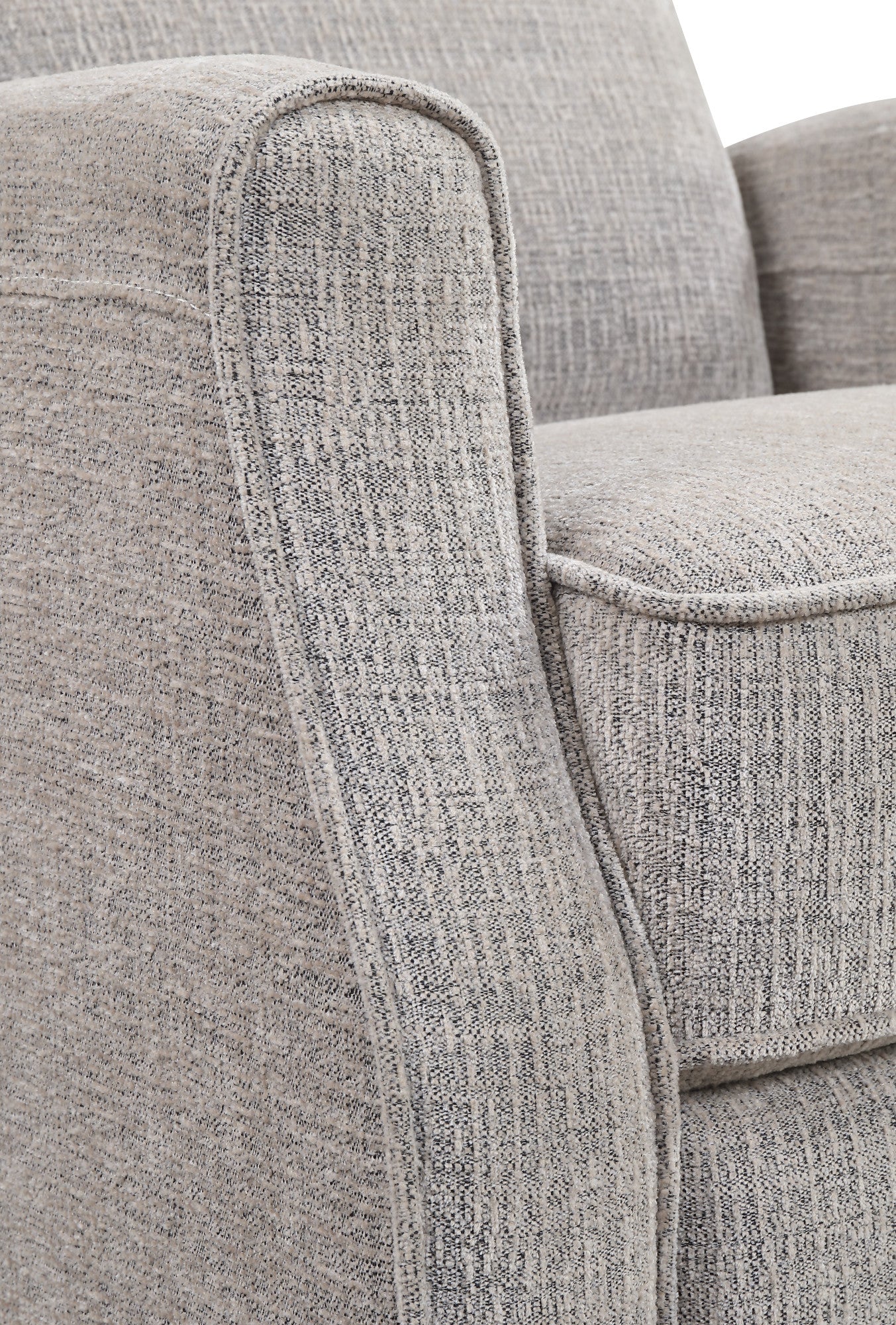 Closeup of a textured grey fabric armchair armrest with piped edges