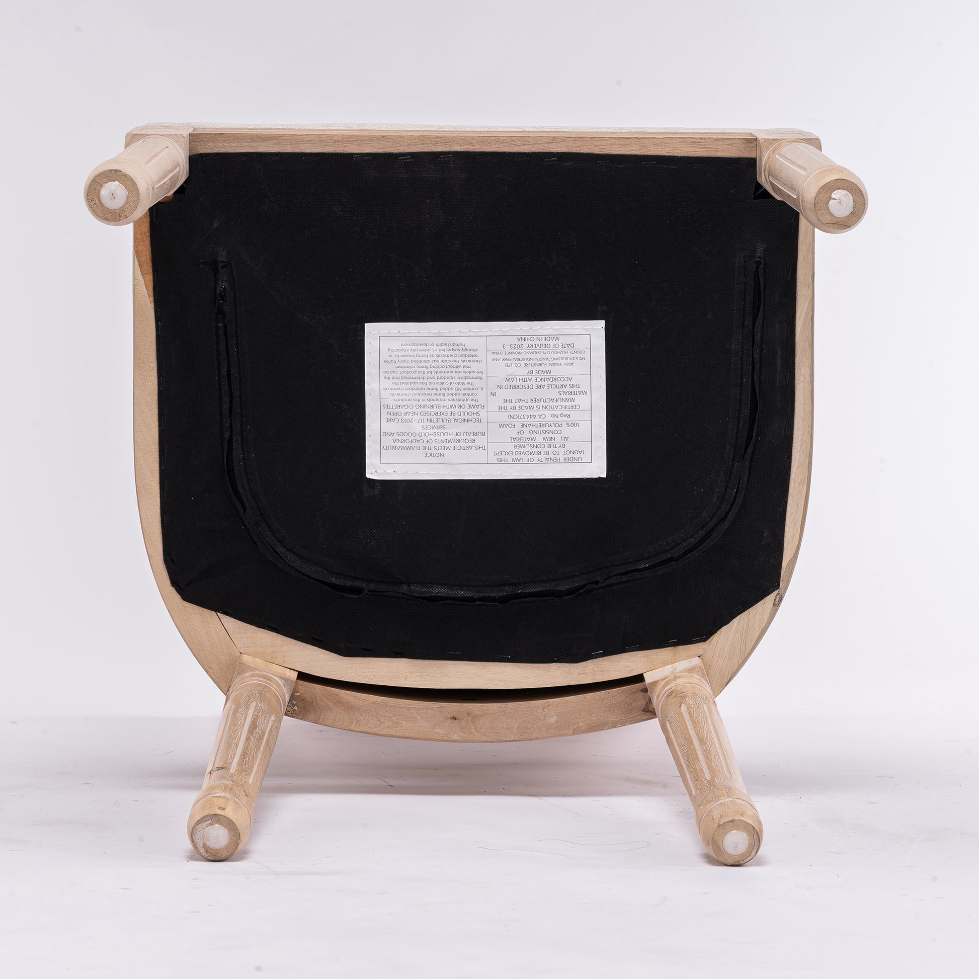 Underside of natural wood armchair with black upholstery and label