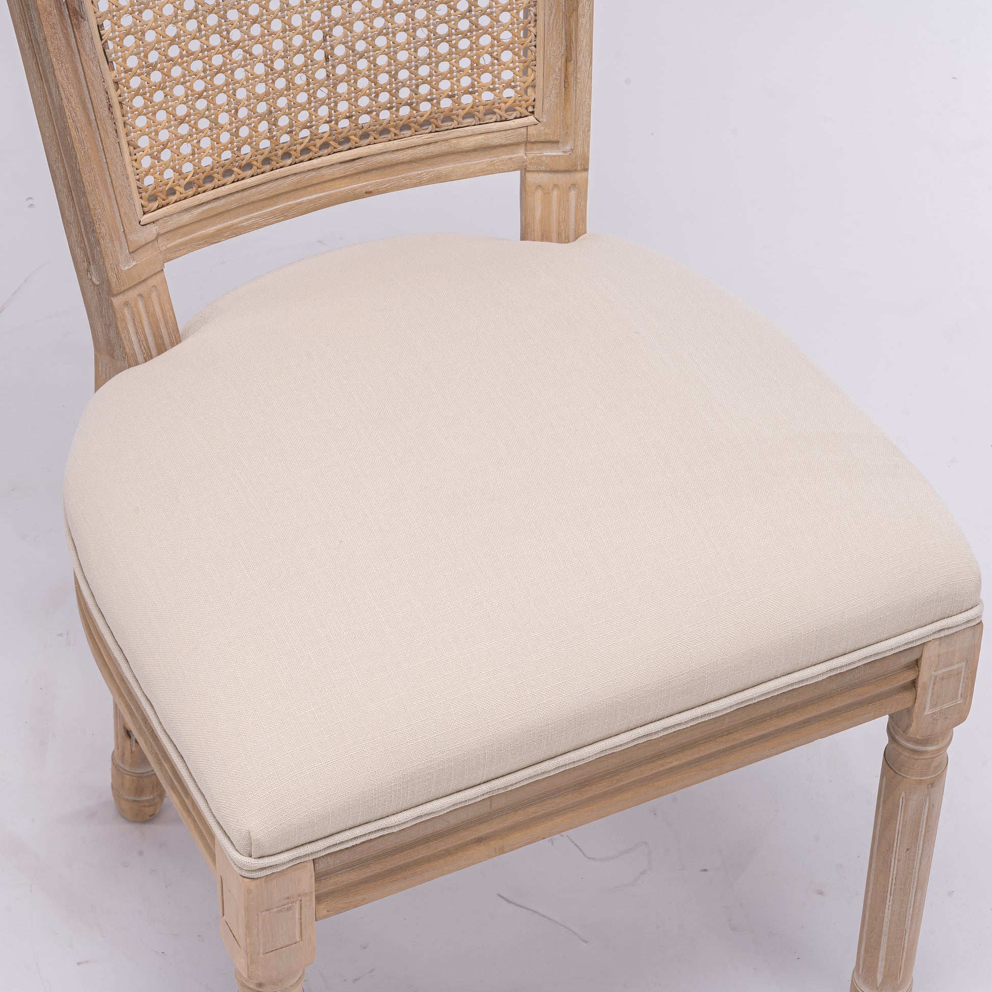 Light wood canebacked dining chair with cream upholstered seat