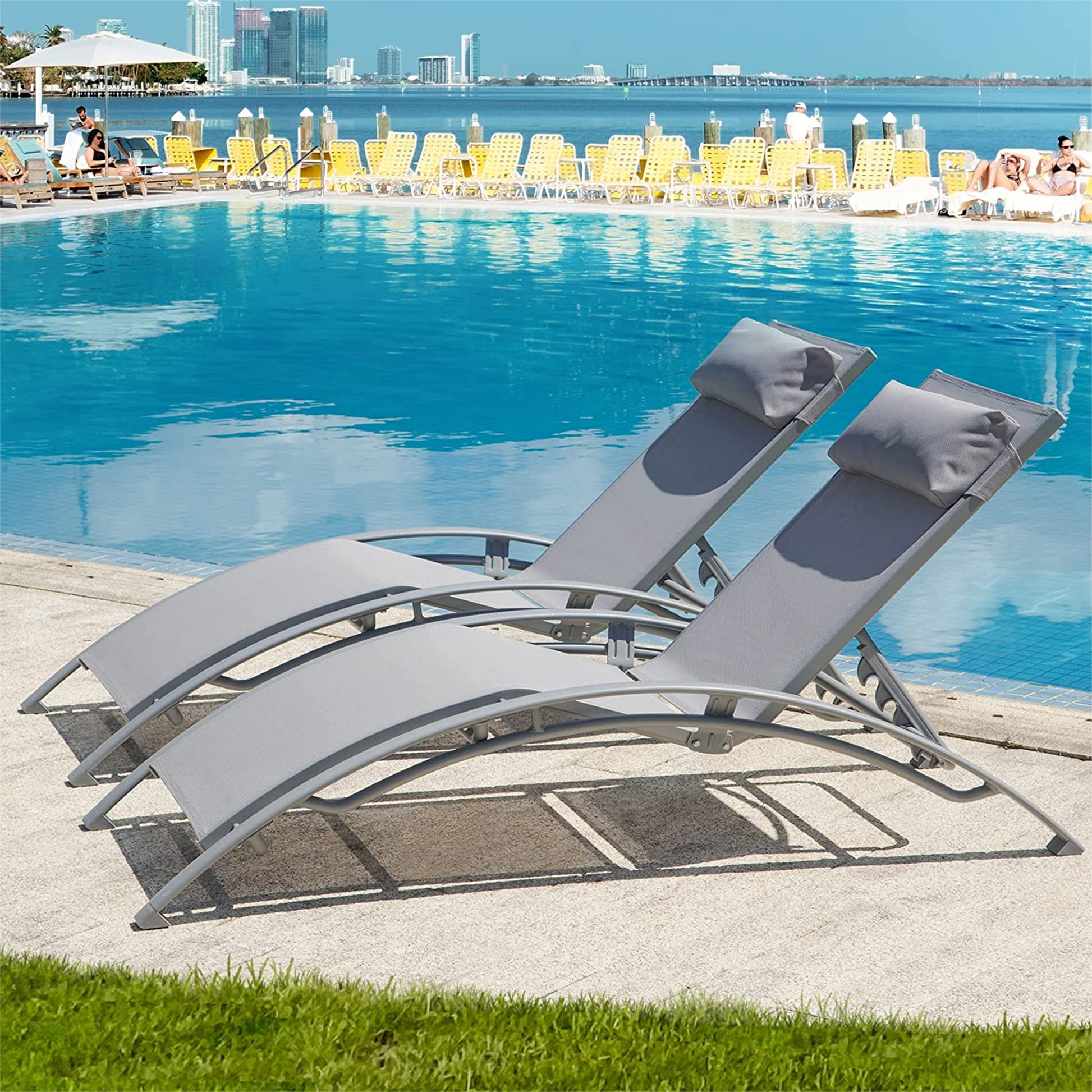Gray adjustable lounge chairs with headrests beside a blue pool