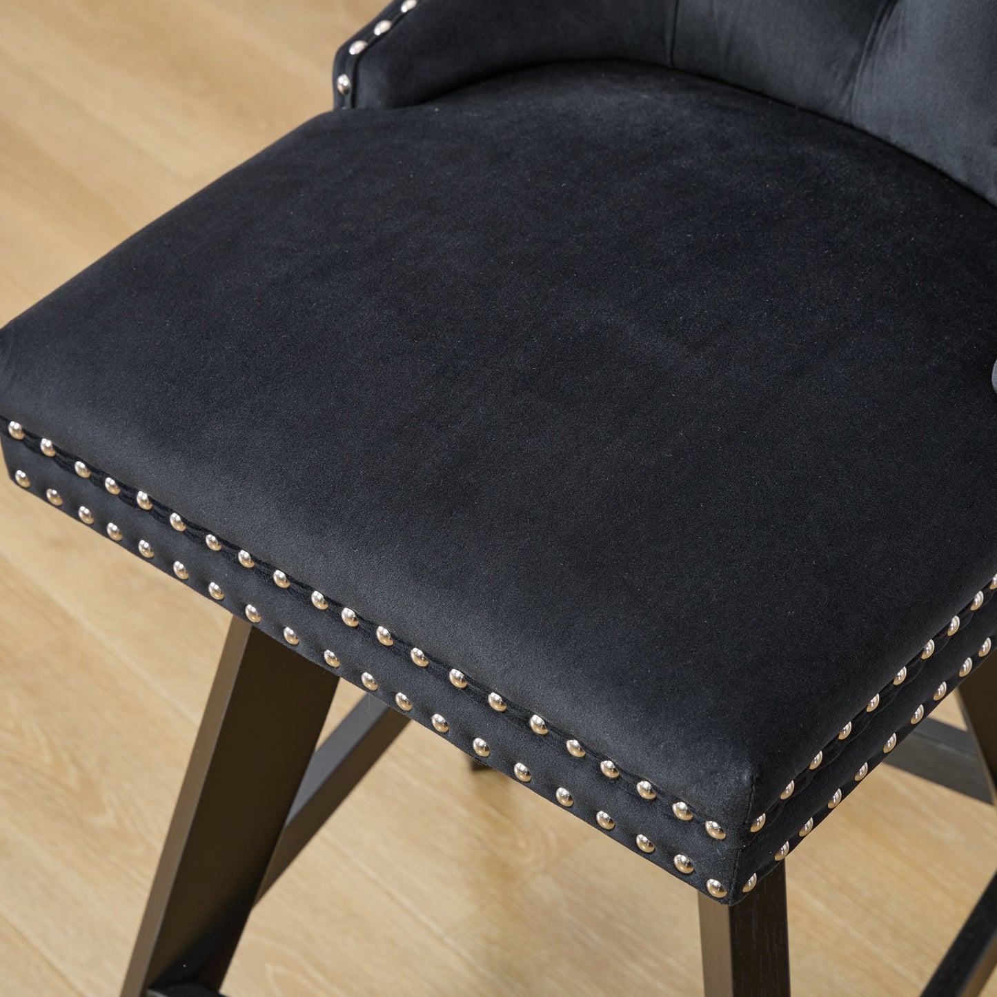 Black velvet bar stool with silver nailhead trim and dark wooden legs