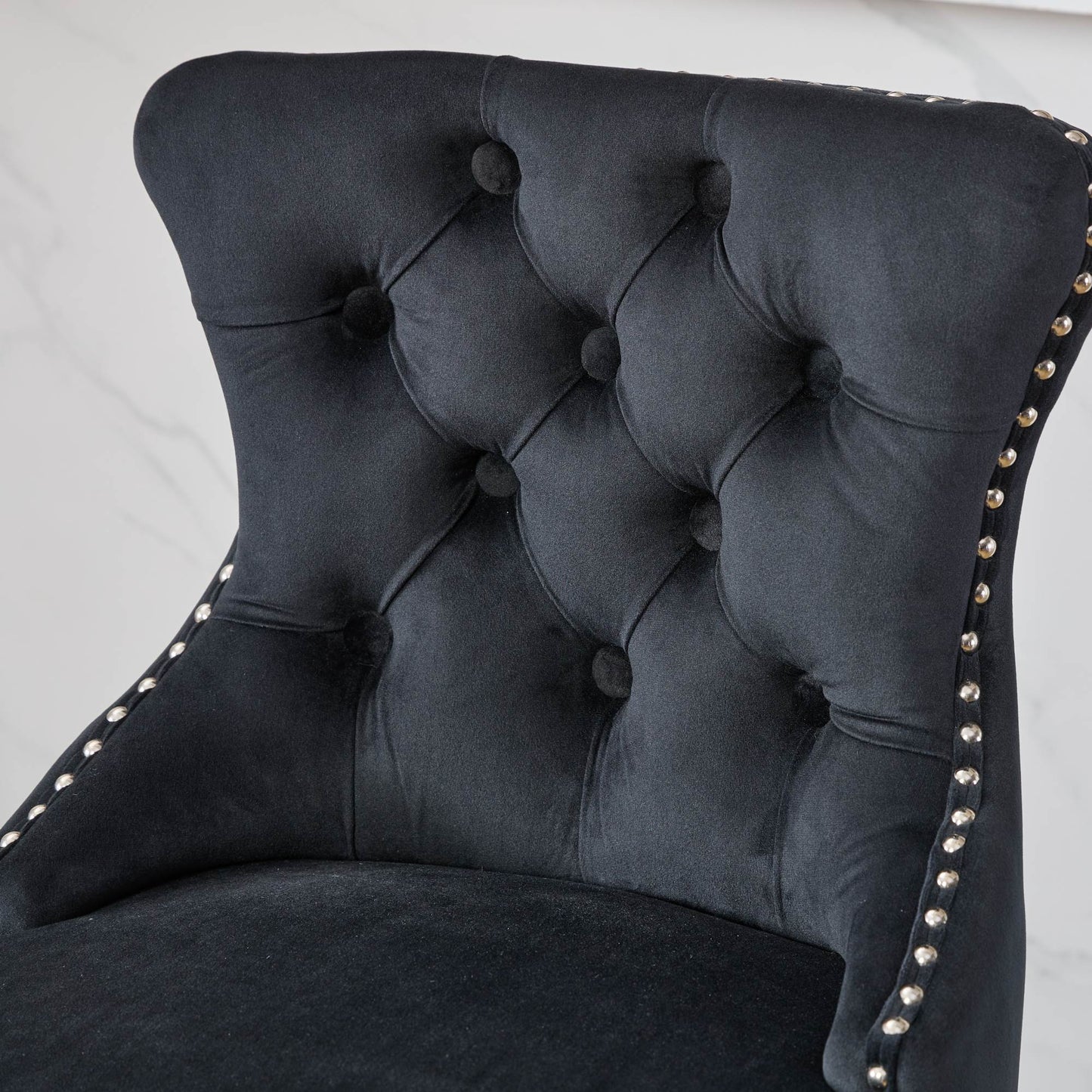 Black velvet accent chair with diamond tufting and silver nailhead trim