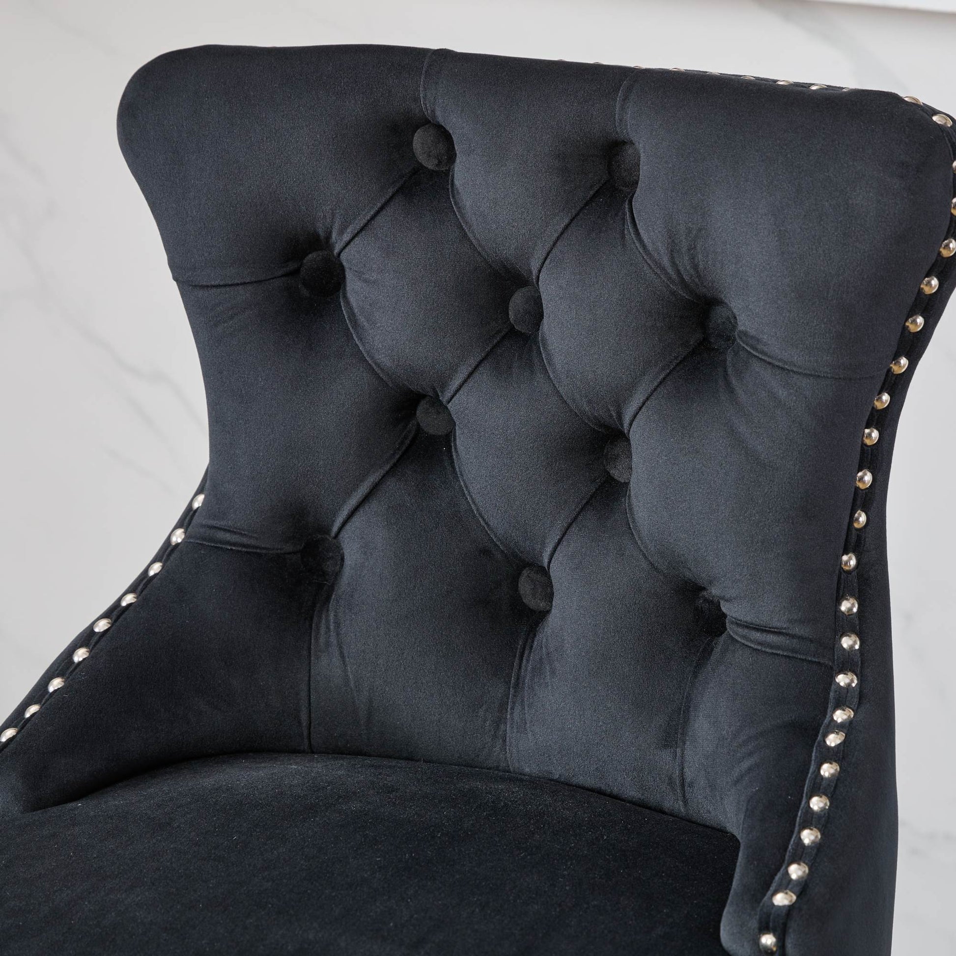 Black velvet accent chair with diamond tufting and silver nailhead trim